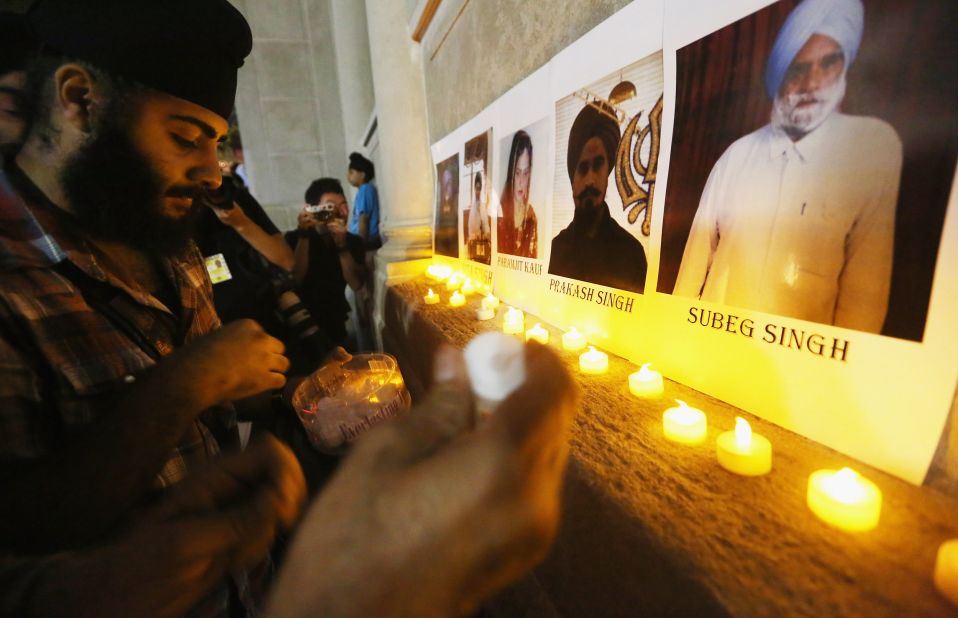 Photos of the victims are displayed during a candlelight vigil Wednesday in New York's Union Square. Six people were killed in the shooting Sunday, August 5, near Milwaukee.