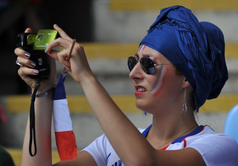 A fan of the French football team snaps some action during the women's football match for bronze between France and Canada.