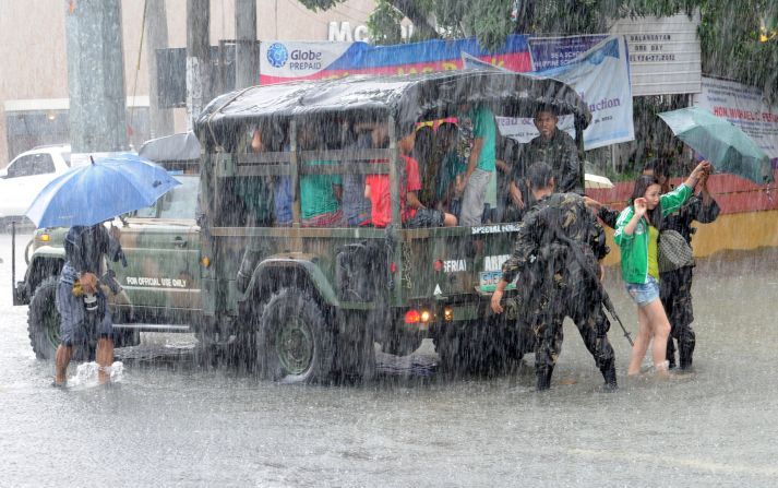 Philippines army soldiers assist people during heavy rains north of Manila on Wednesday, August 8.