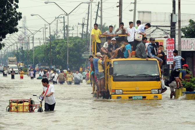 Residents commute through floodwaters in Cainta town in Rizal province, on Thursday.