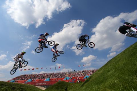 Bikers leap through the course in the men's BMX cycling quarterfinals.