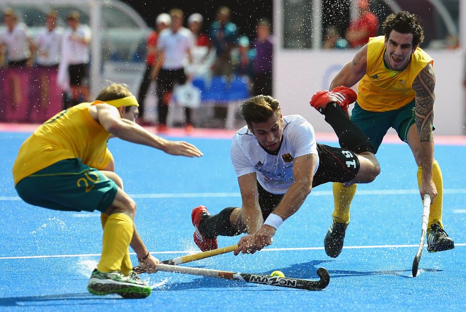 Germany's Christopher Zeller, center, competes with Australia's Matthew Swann, left, and Kieran Govers during the men's field hockey semifinal match.