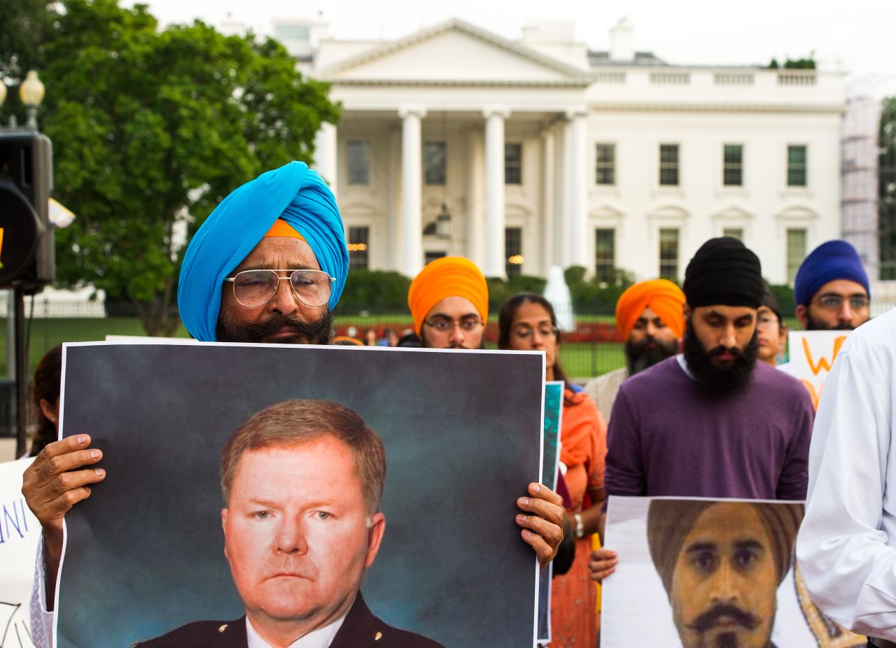 Sikhs gather at Washington's Lafayette Park, across from the White House, for a Night of Remembrance of the Wisconsin Gurdwara Shootings on Wednesday, August 8. The man on the left is holding a poster of Oak Creek Police Officer Lt. Brian Murphy, who was shot multiple times as he pursued the gunman.