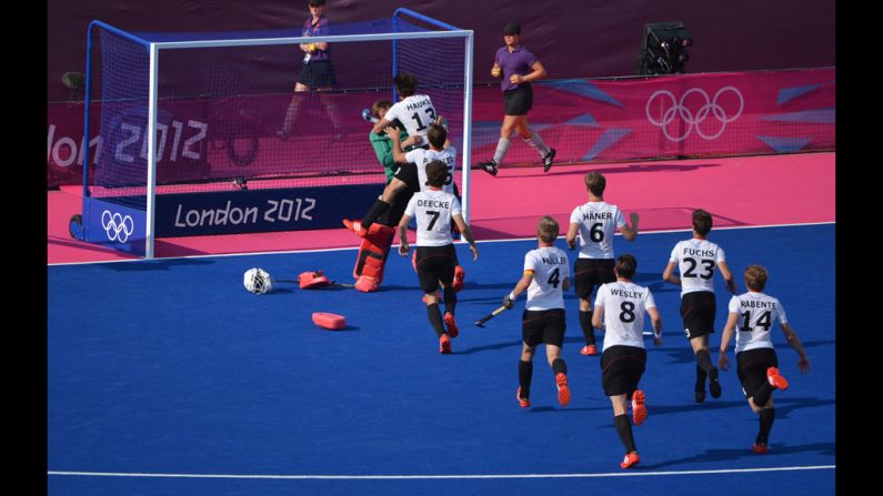 The German team runs toward goalkeeper Max Weinhold after winning the men's field hockey first semifinal against Australia.