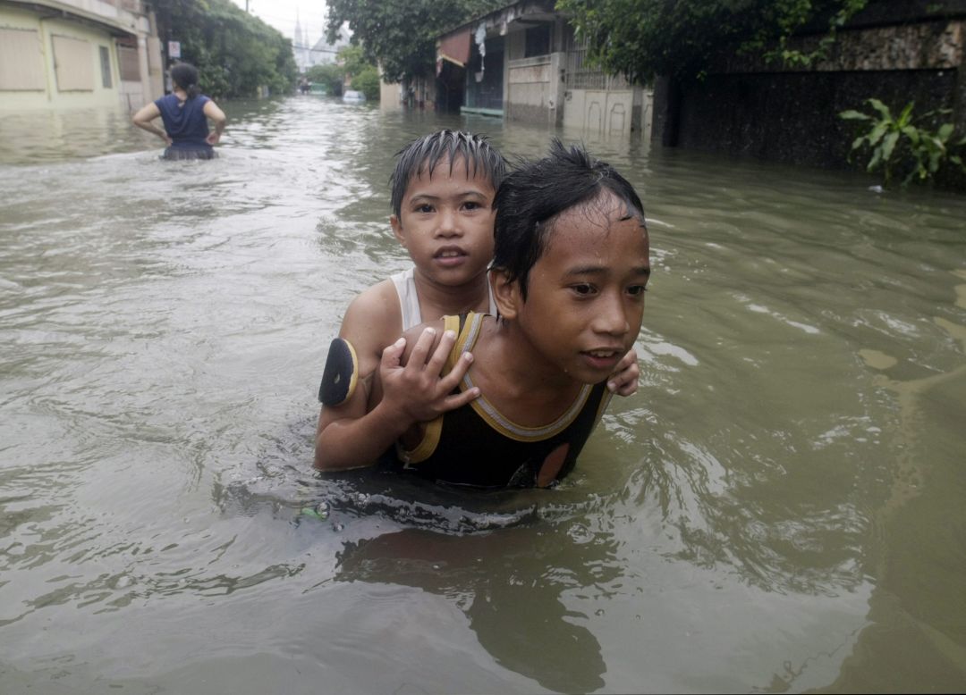Children slog through floodwaters in Pasig City, east of Manila.