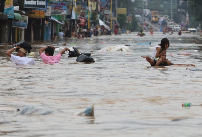 Residents move through chest-high floodwaters in Marikina City, east of Manila.