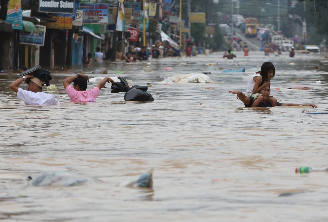 Residents move through chest-high floodwaters in Marikina City, east of Manila.