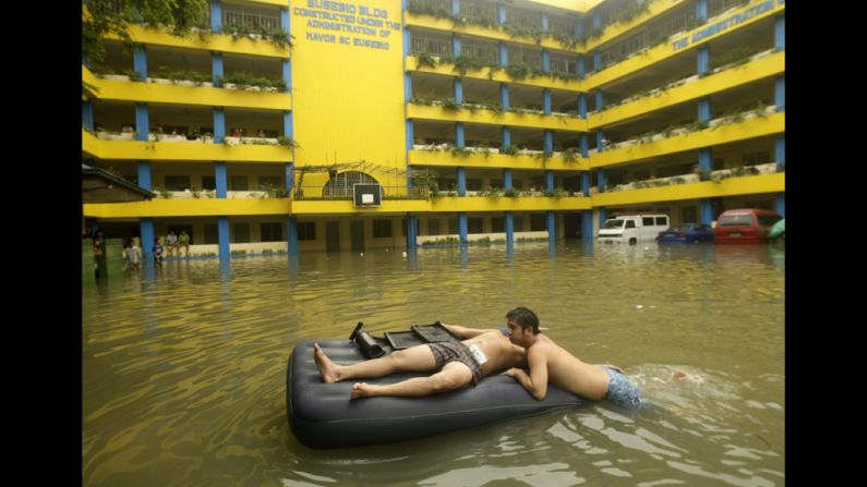 Flood victims rest on an inflated bed on Thursday at a flooded school turned into a temporary evacuation center.