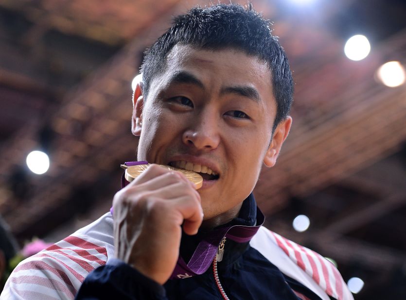 South Korea's Song Dae-nam bites his gold medal after winning a judo event.