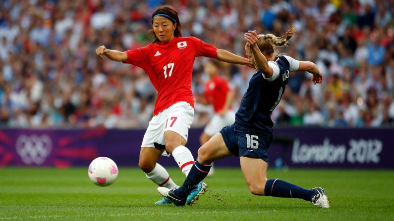 Yuki Ogimi of Japan moves the ball against Rachel Buehler of the United States.
