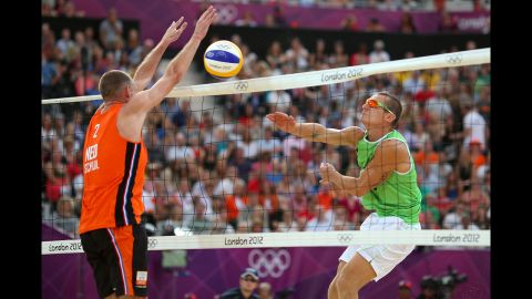 Martins Plavins of Latvia, right, hits a return against Rich Schuil of Netherlands during the men's beach volleyball bronze medal match.