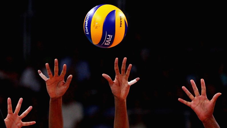 No. 16 Fernanda Rodrigues and No. 6 Thaisa Menezes of Brazil defend the ball from No. 18 Saori Kimura of Japan during the women's volleyball semifinal match.