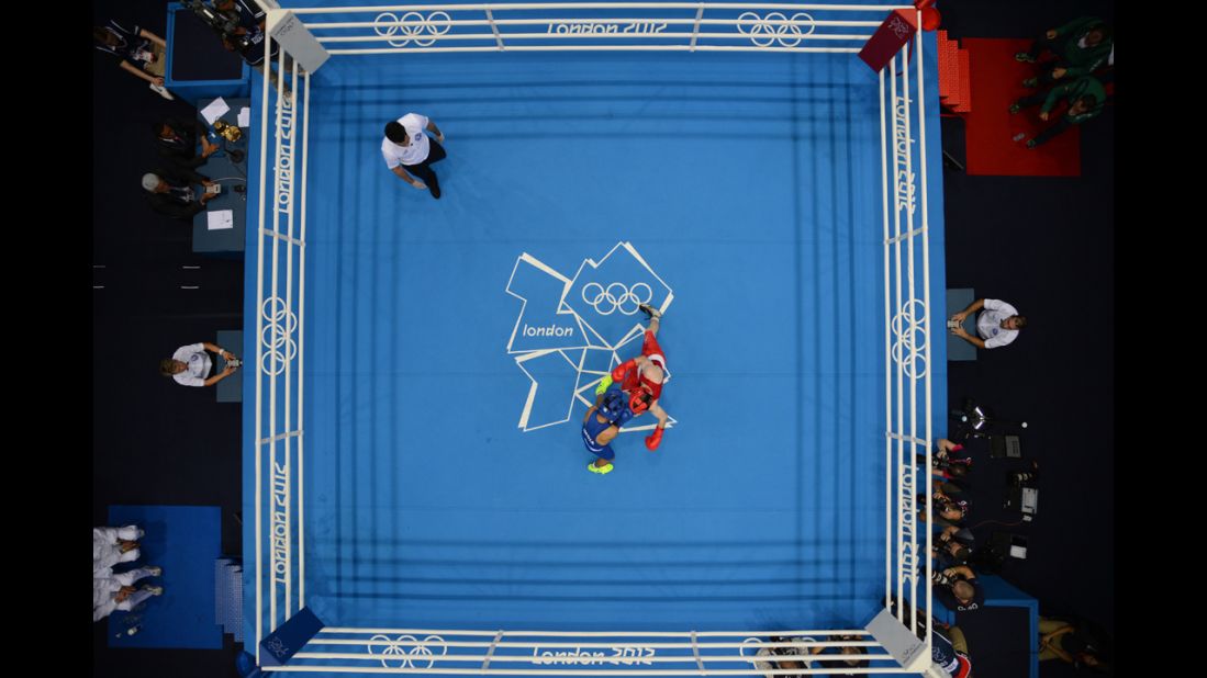 Paddy Barnes of Ireland, in red, defends against Devendro Singh Laishram of India, in blue, during the light flyweight boxing quarterfinals.