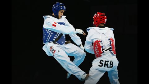 Peru's Peter Lopez Santos, left, faces off against Damir Fejzic of Serbia in the preliminary round men's under 68-kilogram taekwondo match.