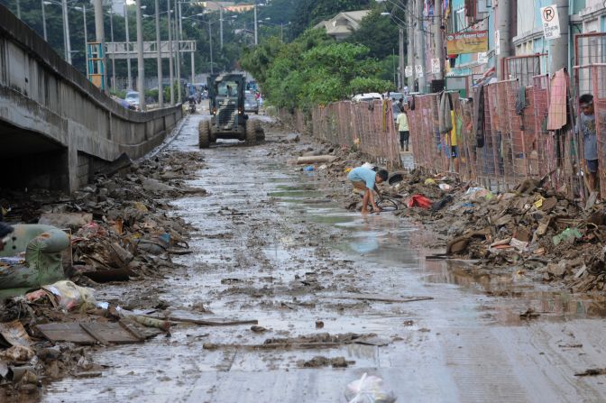 Philippine army corp engineers clear mud and debris from a street in a Manila suburb on Friday, August 10, after days of heavy rain and flooding.