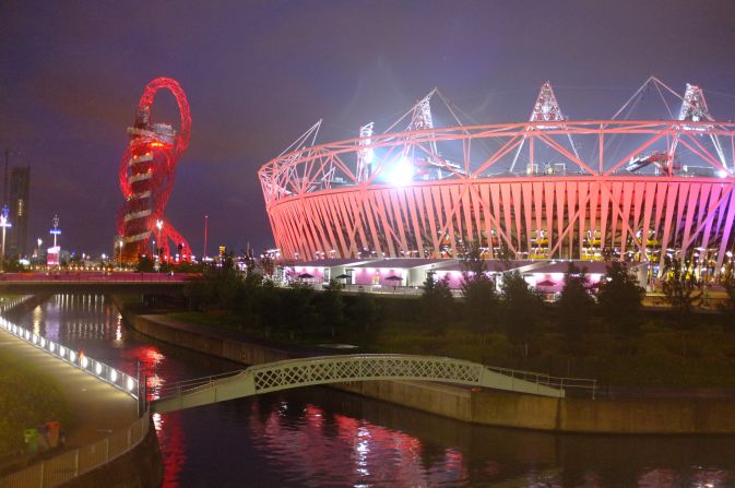 The stadium and the Orbit stood out against the cloudy East London sky and reflected in the River Lea, which flows through the park. The stadium was hosting athletics that night. 