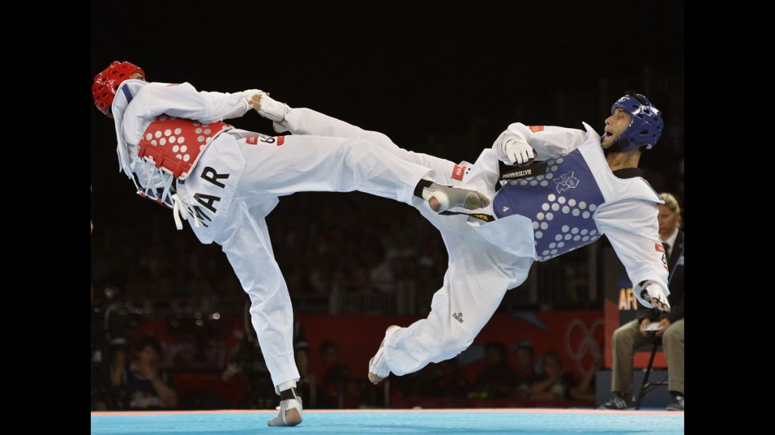 Morocco's Issam Chernoubi, left, battles Afghanistan's Nesar Ahmad Bahawi in the men's under 80-kilogram taekwondo bout.