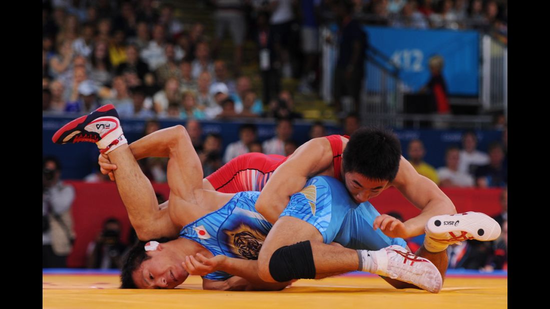 South Korea's Jincheol Kim, right, and Kenichi Yumoto of Japan compete in the men's freestyle 55-kilogram wrestling.