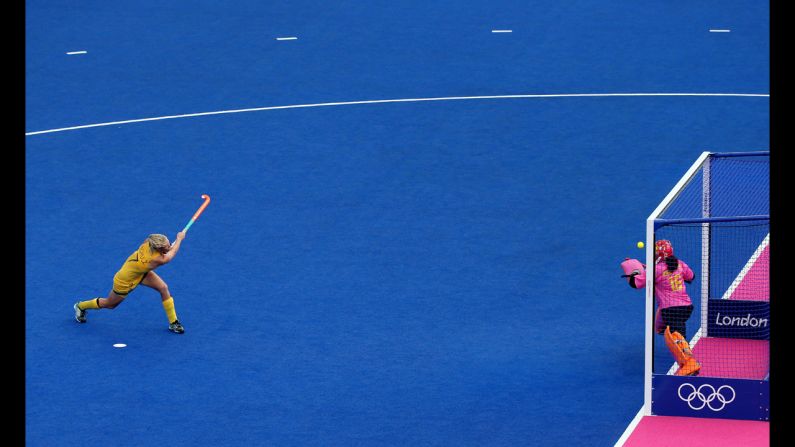 Australia's Jodie Schulz, left, shoots a penalty shot against Chinese goalkeeper Yimeng Zhang during the women's field hockey classification match.
