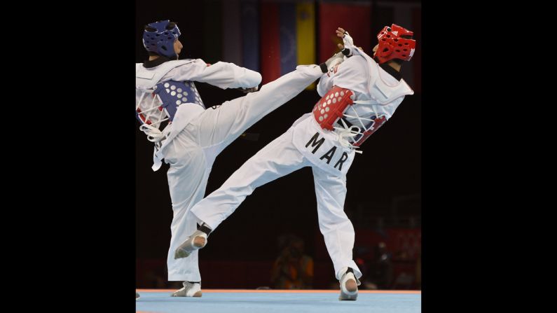 Afghanistan's Nesar Ahmad Bahawi, left, directs a kick against Morocco's Issam Chernoubi during the men's under 80-kilogram taekwondo bout.