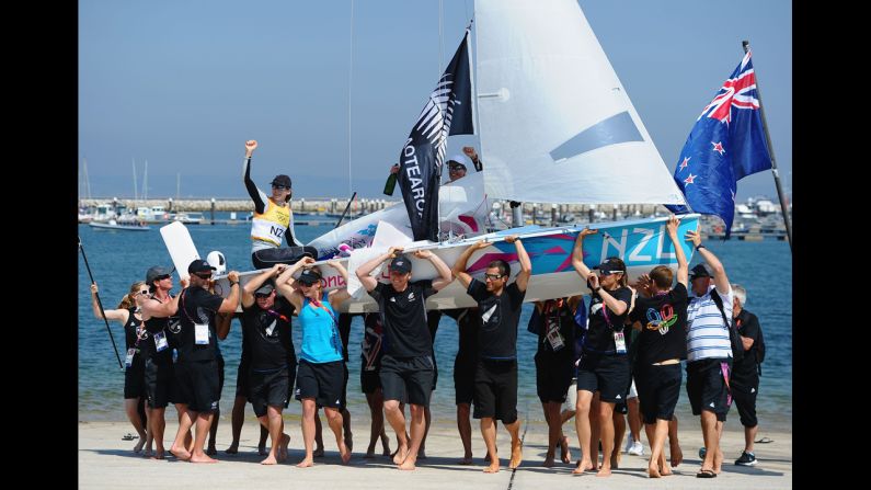 Jo Aleh, left, in the black cap, and Olivia Powrie, in the white cap, of New Zealand celebrate  winning the gold medal in the women's 470 sailing class.
