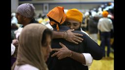 Mourners embrace at a memorial service Friday, August 10, for the six people killed in last weekend's shooting at a Sikh temple in Oak Creek, Wisconsin. Family and friends gathered at Oak Creek High School in suburban Milwaukee.