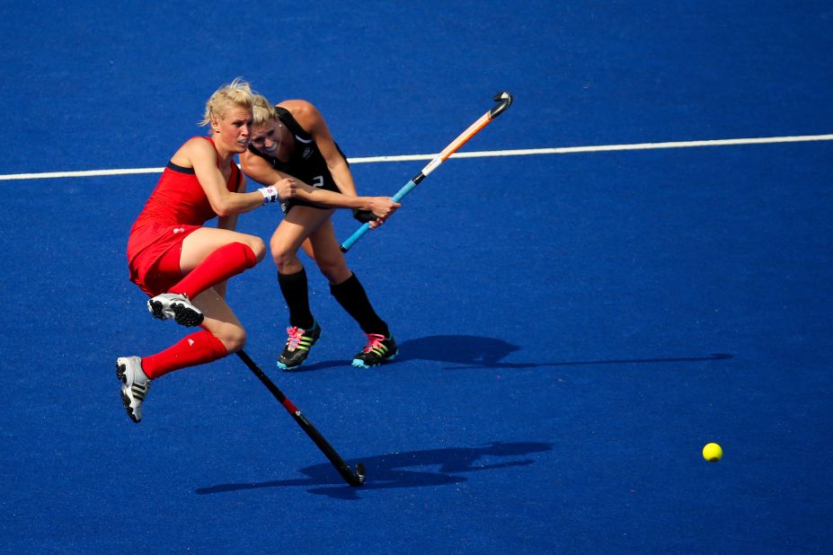 Great Britain's Alex Danson, left, jumps out of the way of New Zealand's Emily Naylor during the women's field hockey bronze medal match.