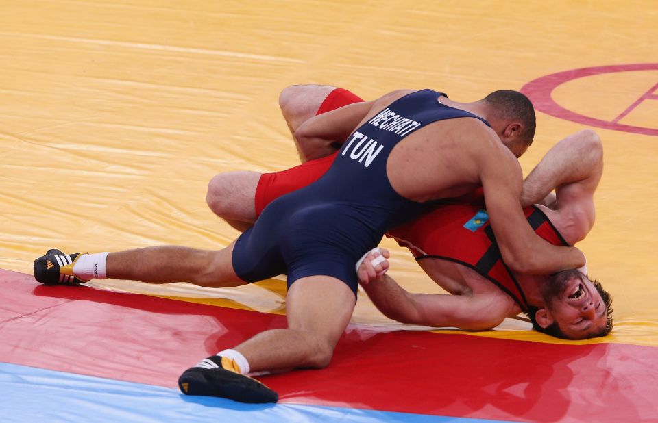 Kazakhstan's Abdulkhakim Shapiyev, right, fights Bilel Ouechtati of Tunisia during the men's freestyle wrestling (74-kilogram) 1/8 final bout.