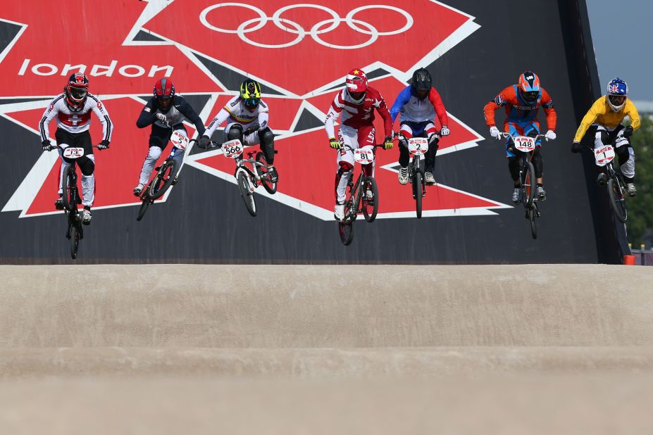 Cyclists race down the starting ramp in the  in the men's BMX cycling final.