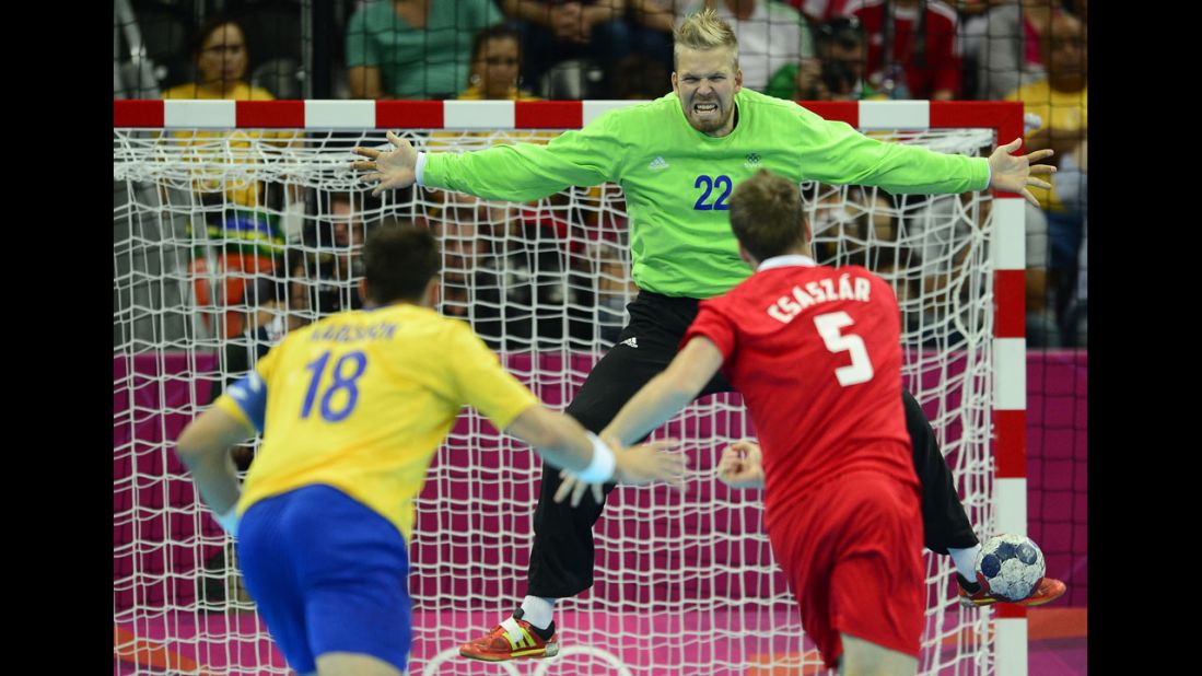 Hungary's center back Gabor Csaszar, right, shoots against Sweden's goalkeeper Johan Sjostrand during the men's semifinal handball match against Sweden.
