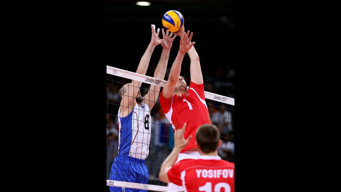 No. 1 Georgi Bratoev of Bulgaria tries to tip the ball over the net against No. 8 Sergey Tetyukhin of Russia during the men's volleyball semifinals.