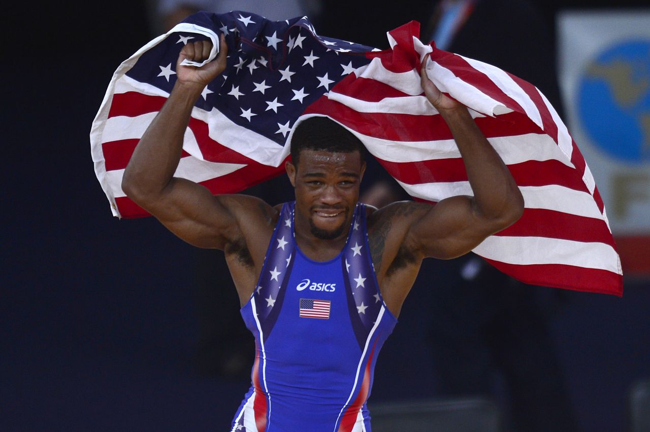 U.S. wrestler Jordan Ernest Burroughs celebrates with the national flag after defeating Iran's Sadegh Saeed Goudarzi in the men's freestyle gold medal match.