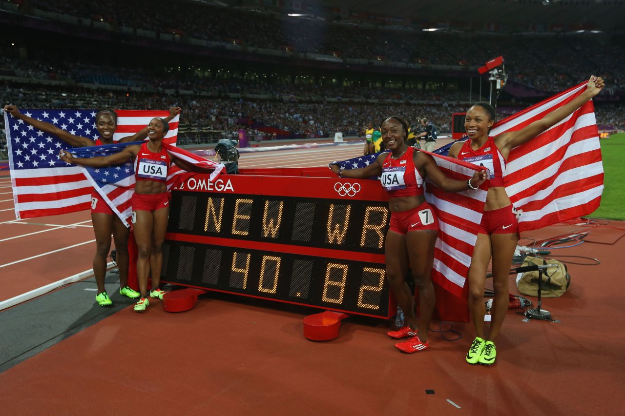 Carmelita Jeter, Bianca Knight, Allyson Felix and Tianna Madison of the United States celebrate next to the clock after winning gold and setting a new world record of 40.82 seconds in the women's 4x100m relay final.