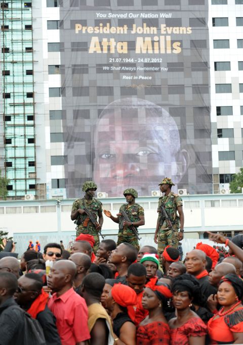 Soldiers stand on a platform behind mourners queuing Thursday outside the parliament to pay tribute to Mills. 