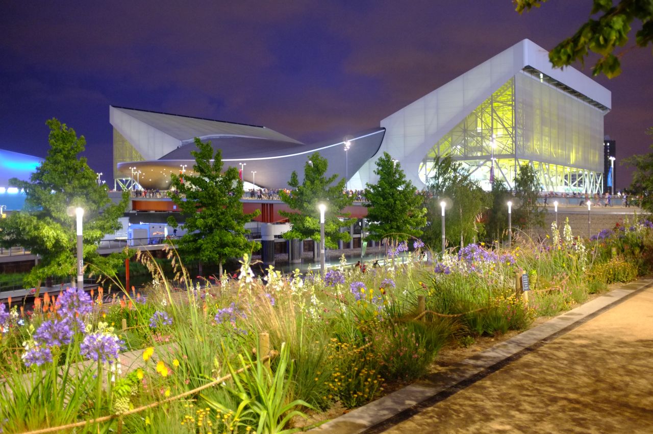 The Aquatic Centre shone neon yellow beyond wildflower planting on the banks of the River Lea. The venue's curved center, designed by architect Zaha Hadid, will remain after the Games. The sweeping wings either side are temporary stands that will be dismantled at the end of the Games. 