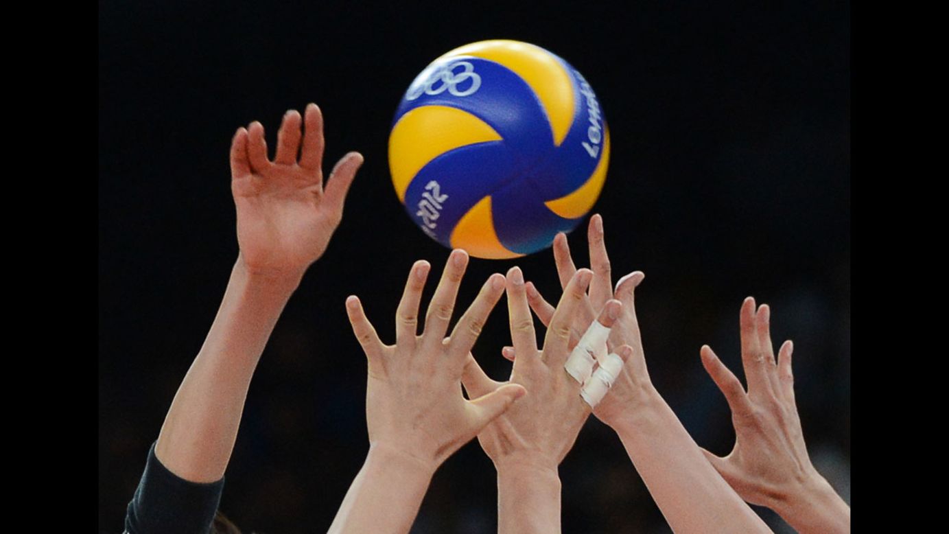 Japanese and South Korean players stretch for the ball during the women's volleyball bronze medal match.