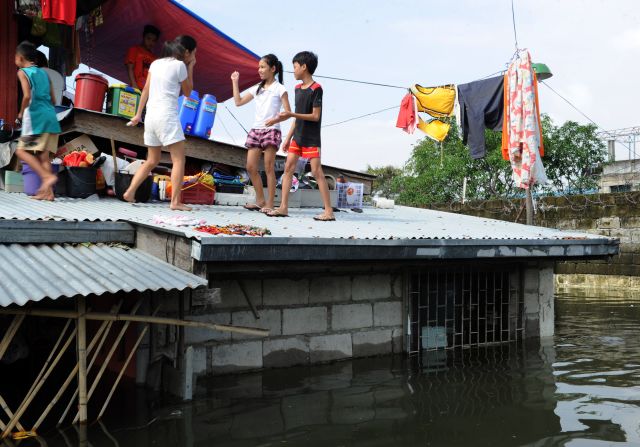 A family gathers on the roof of a home in Calumpit town, north of Manila.