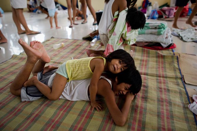 Children play at an evacuation center at a municipal building Friday in the township of Paombong on the outskirts of Manila.