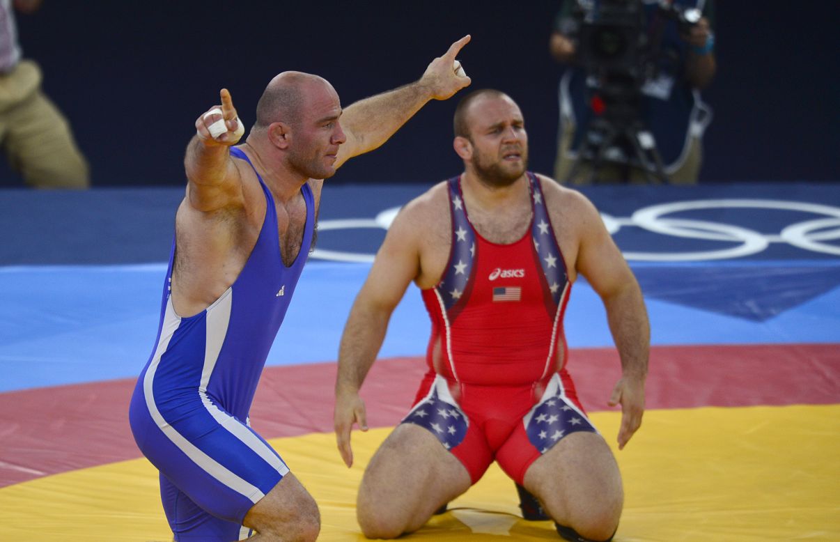 The United States' Tervel Ivaylov Dlagnev, right, and Uzbekistan's  Artur Taymazov react after Taymazov won a match in the men's freestyle wrestling semifinal event.