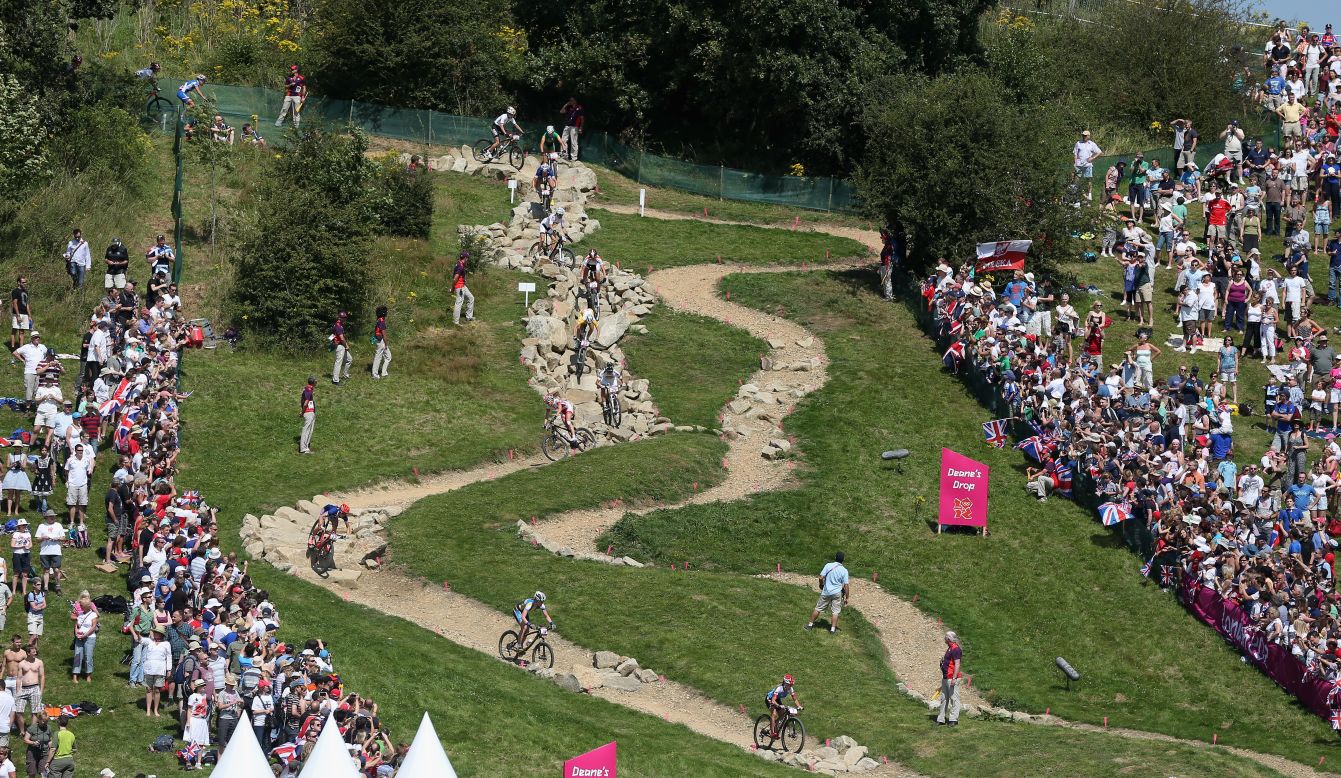 Women's cross-country mountain bike competitors race down Deane's Drop, a section of the course named for a school.