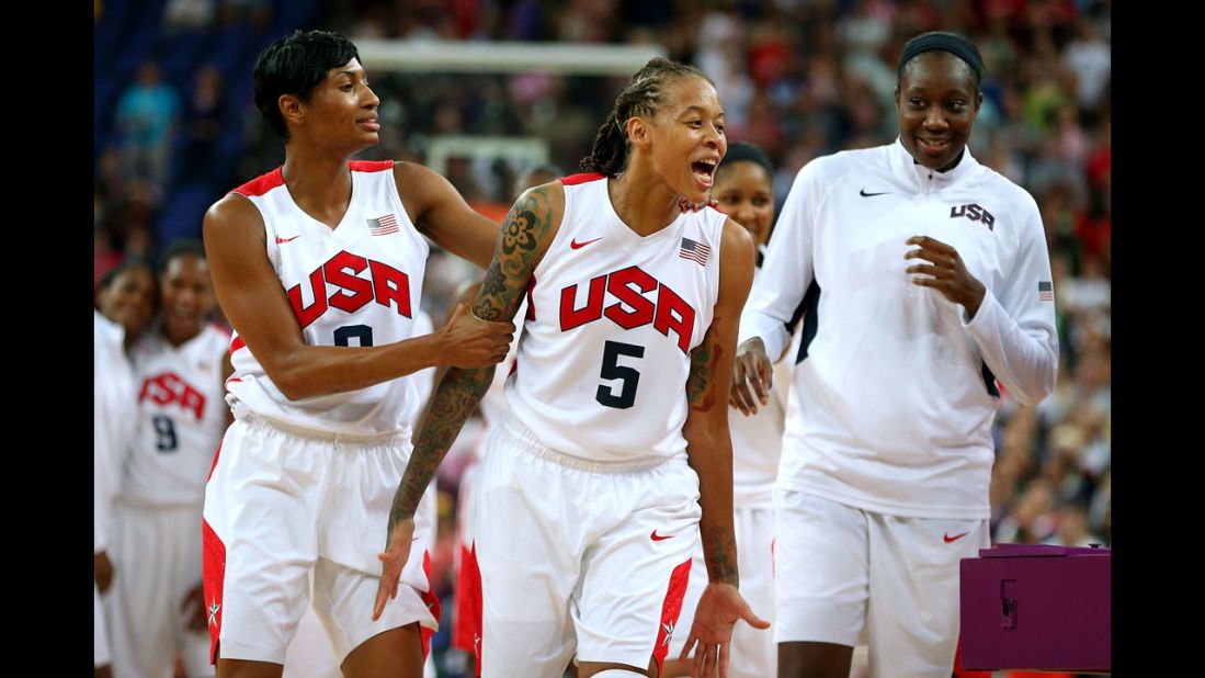 Seimone Augustus, number 5, and Angel McCaughtry, number 8, celebrate with the rest of the U.S. women's basketball team after defeating France 86-50 to win the gold medal.