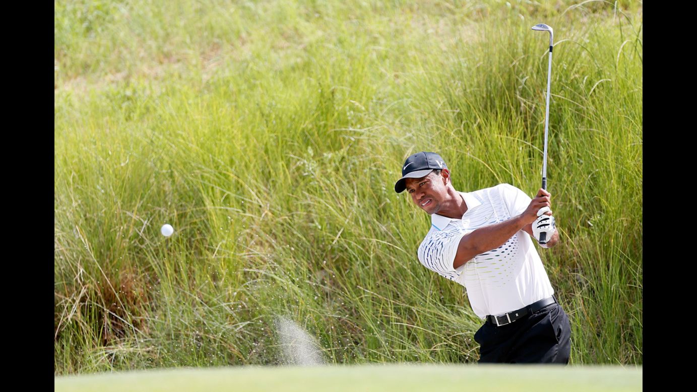 Tiger Woods of the United States hits out of the sand on the seventh hole.