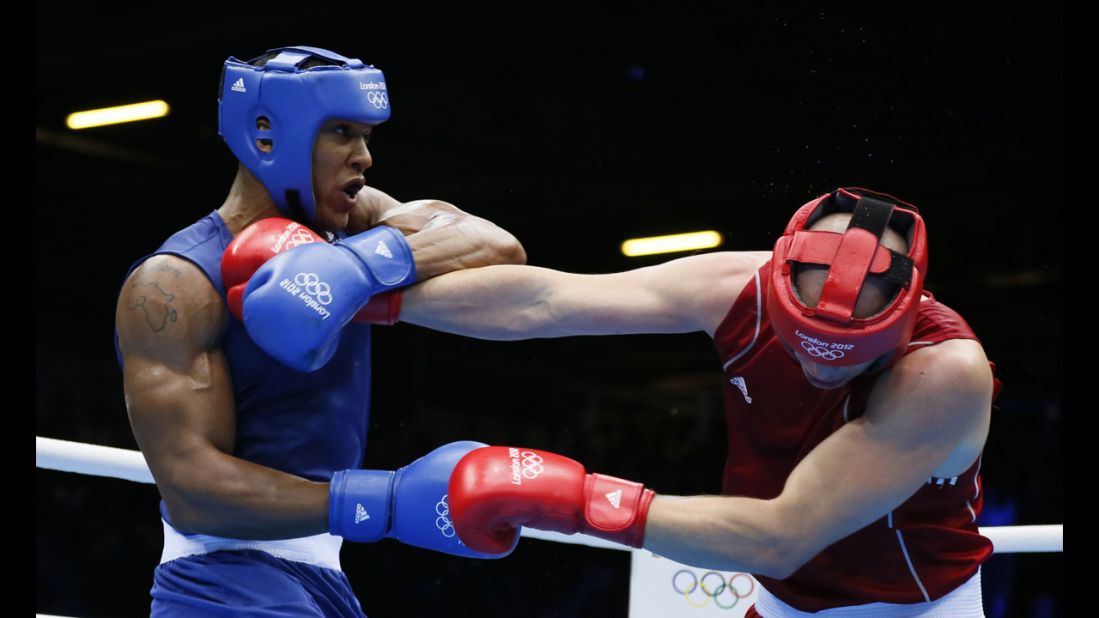 Ivan Dychko of Kazakhstan, in red, defends against Anthony Joshua of Great Britain, in blue, during the men's super-heavyweight (+91 kilogram) boxing semifinals.