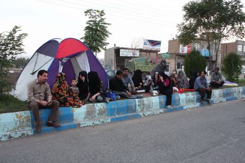 An Iranian family sits by a tent they erected along a street in Varzaqan, a town located 37.2 miles (60 kilometers) northeast of Tabriz, Iran.