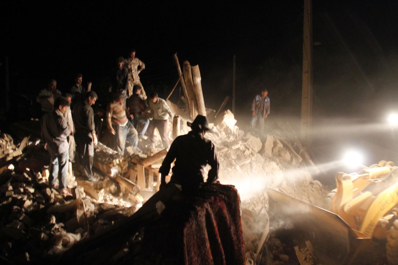 Aided by searchlights, residents and rescue workers search for survivors in the rubble of a village near Varzaqan on Saturday.
