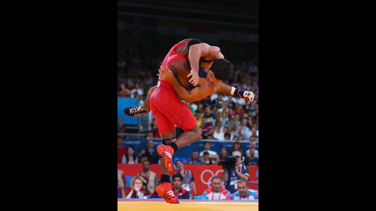 Livan Lopez Azcuy, in red, of Cuba grapples with Jabrayil Hasanov of Azerbaijan during the men's freestyle 66-kilogram wrestling bronze medal bout in London.