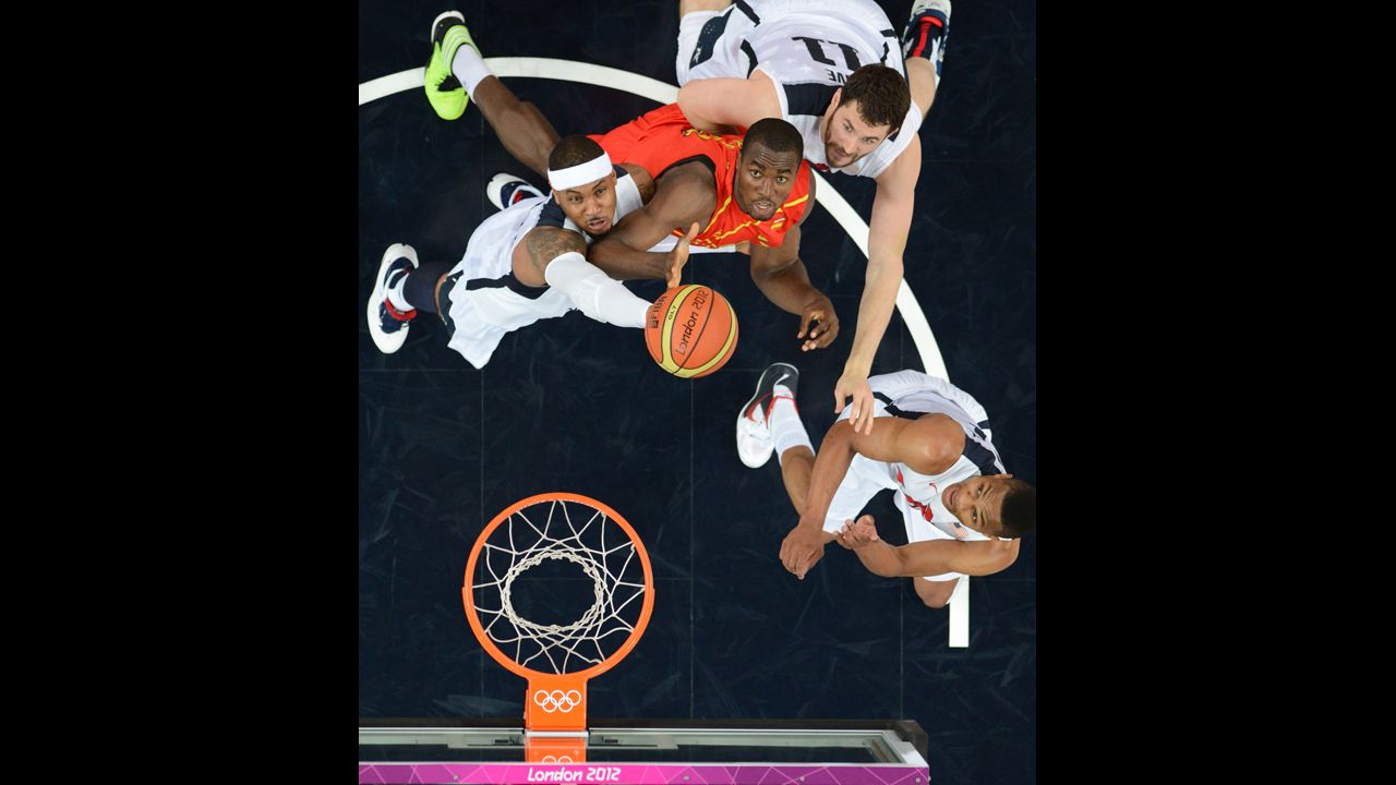 U.S. forward Carmelo Anthony, left, and Spanish center Serge Ibaka struggle for the ball during the men's gold medal basketball game between the United States and Spain.