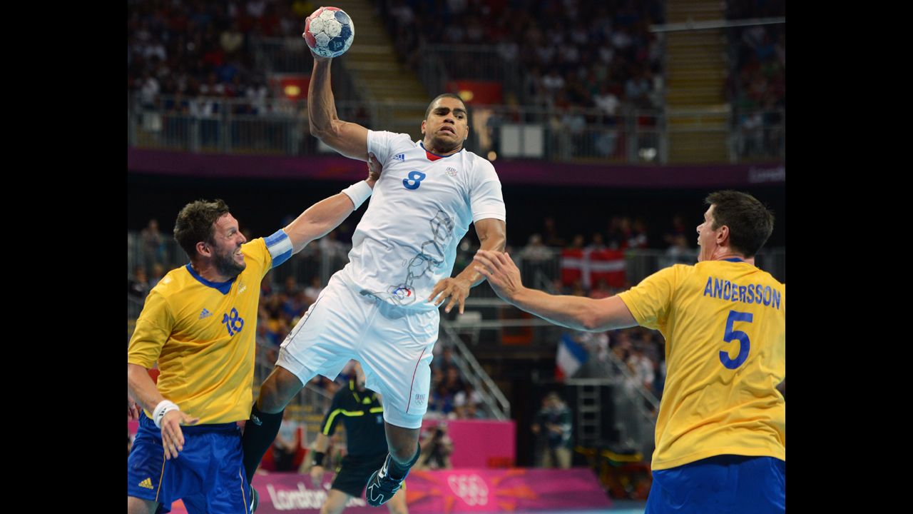 France's centerback Daniel Narcisse, center, is challenged by pivot Tobias Karlsson, left, and right back Kim Andersson of Sweden during the men's gold medal handball match between Sweden and France.