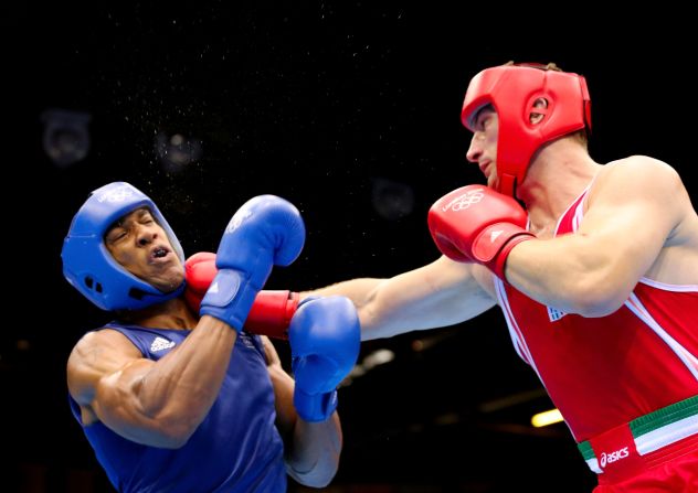 Sweat flies off Anthony Joshua of Great Britain as he takes a punch from Roberto Cammarelle of Italy during the men's super heavyweight boxing final bout. Joshua went on to win the gold medal.