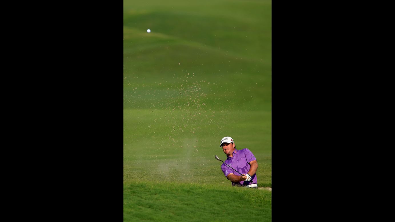 Graeme McDowell of Northern Ireland hits out of a bunker on the 18th hole during round three.